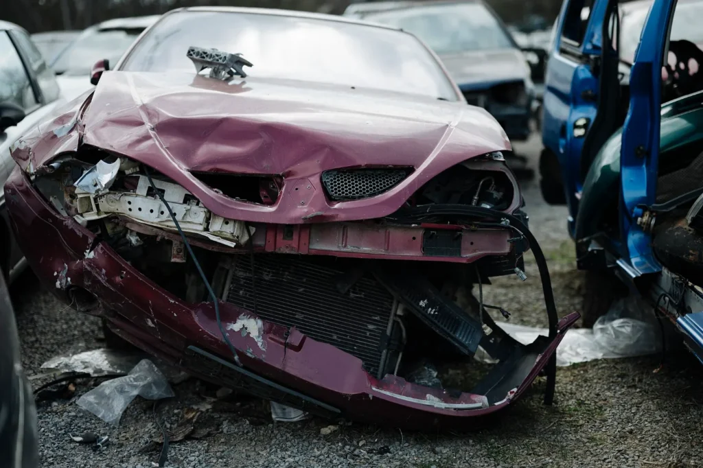 Carro con daño frontal en un patio de salvamento, como los que se compran con título salvage para reparar