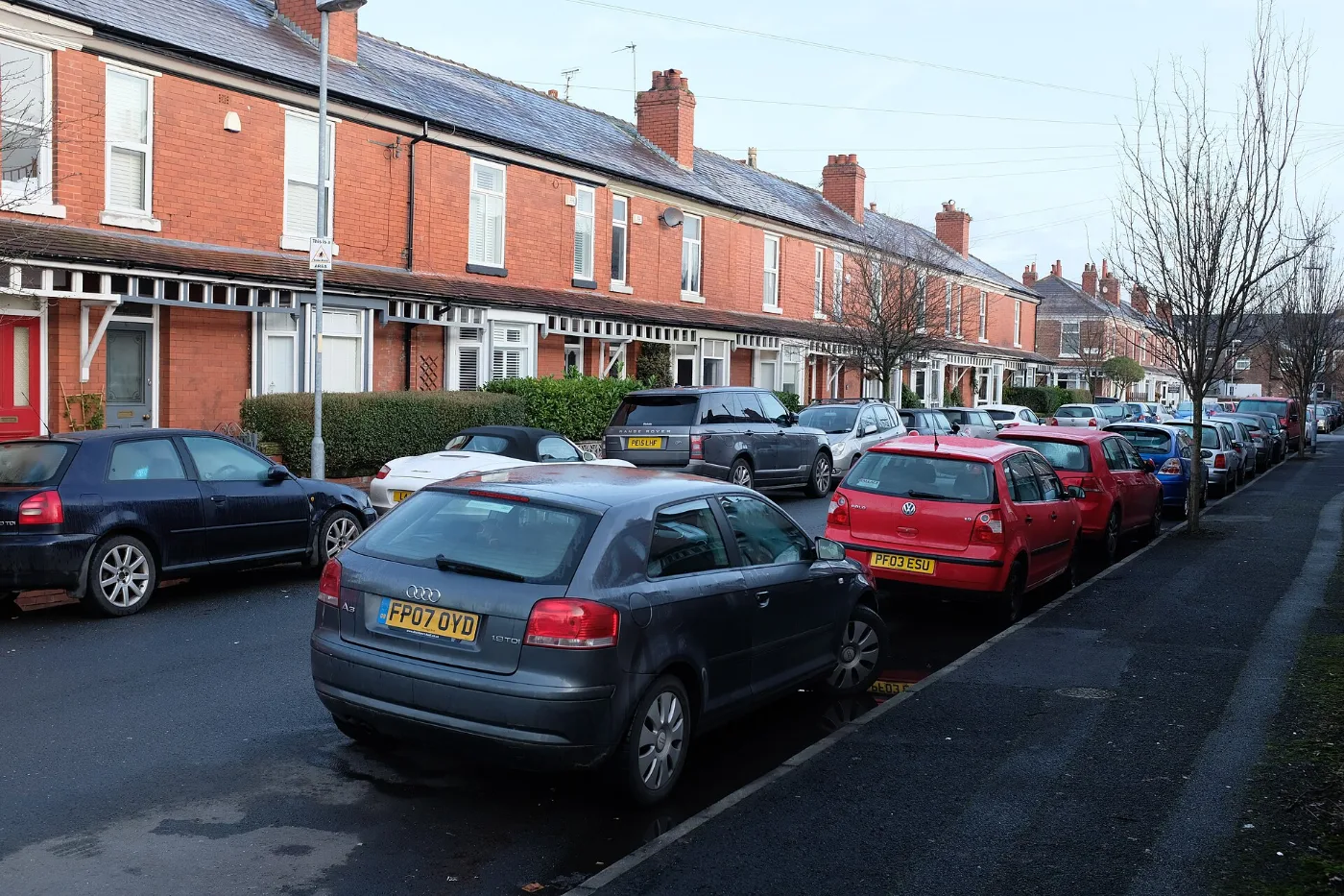 Carros estacionados en una calle residencial: con placa temporal vencida también cuentan las infracciones estacionado