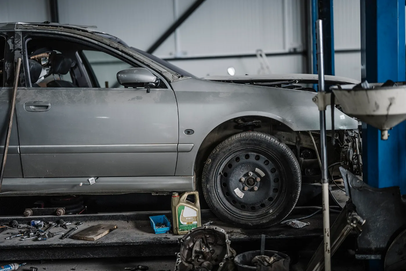 Mecánico revisando un carro en un taller, donde se verifica el VIN antes de transferir el título