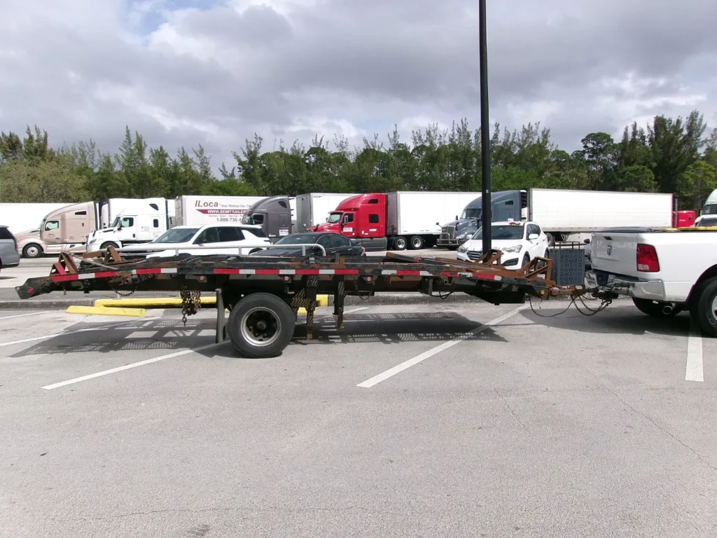 Camioneta pickup estacionada con un remolque plataforma enganchado, ejemplo de troca y tráiler que llevan placa temporal